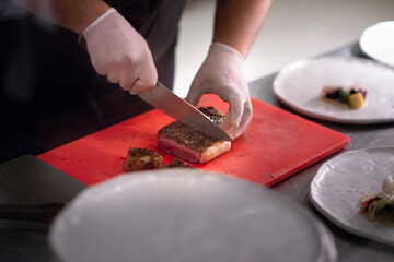 chef chopping steak in kitchen