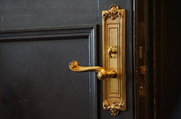 Golden handle of the old wooden door