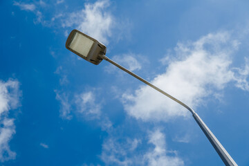 Street lantern on sky with white clouds background.A modern street LED lighting pole.