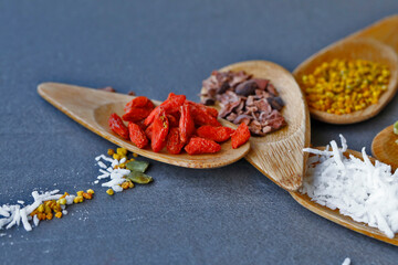 Various legumes and different kinds of nuts in spoons. Walnuts kernels ,hazelnuts, almond ,brown pinto ,soy beans ,flax seeds ,chia ,red kidney beans and pecan set up on white gray background