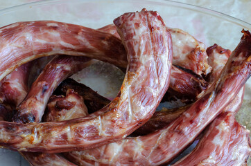 Sun-dried turkey necks in a glass dish.