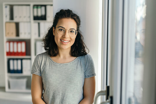 Portrait of young smiling brunet woman in office