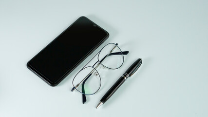 isolated eye wear with mobile and pen all black with white background