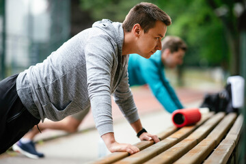 Young men exercising on a race track. Two young friends training outdoors.	