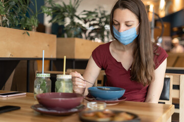 New normal concept of woman with mask eating in restaurant 
