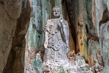 Fototapeta na wymiar The great Buddha stone statue in the cave of Marble mountains, south of Da Nang city, Vietnam