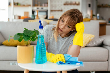 Young attractive angry woman cleaning home. Young tired woman at home.	