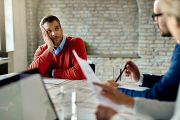 Male candidate talking to members of human resource team during job interview.