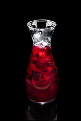 cold drink in a jar with fresh berries and ice on a black background