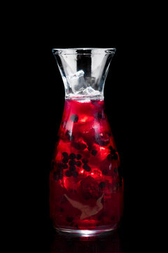 cold drink in a jar with fresh berries and ice on a black background