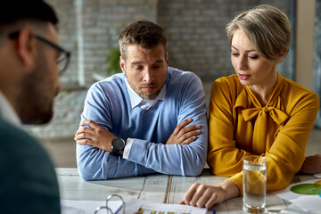 Mid adult couple having a meeting with real estate agent in the office.