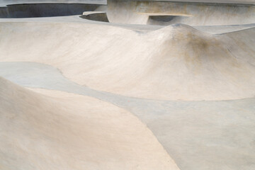 Concrete public skate park on a sunny day. Cement ramps for skateboarding and bmx. Extreme sport