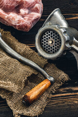 Fototapeta na wymiar classic vintage household manual handle meat grinder on a dark brushed wooden table surface