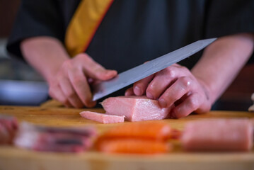 Japanese chef is neatly cutting on fine meat