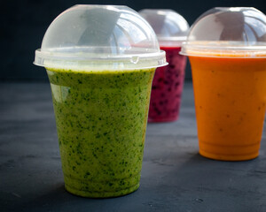 Three colorful bright smoothies - green, pink and orange