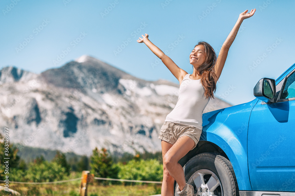 Wall mural Happy road trip tourist girl enjoying driving sport car on summer travel adventure freedom vacation. Asian woman with open arms in freedom.