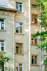 Close up cityscape day view of the beige brick building facades with windows meaning in Russia.