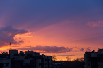 Pink orange purple sunset over the city. Multicolored sky and black silhouette tall buildings of the metropolis