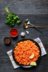 Tomato onion rice on a black plate