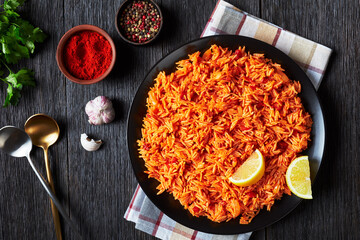 Tomato onion rice on a black plate