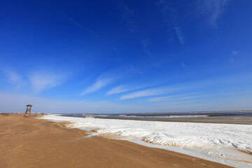 Watchtower on the sea, snow in the blue sky