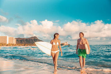 Hawaii Honolulu couple surfers happy on waikiki beach with surfboards. Healthy active sport...