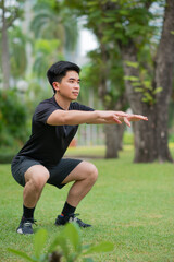 asian young man do squat  excercise in park