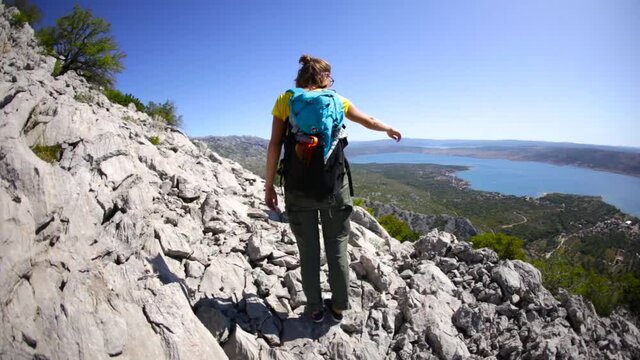 Two women travel with backpacks, Friends go camping in the mountains, Girls on a hilltop against the backdrop of the sea, Traveling around Croatia.