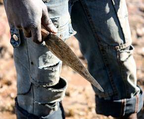Makeshift primitive knife in the hand of a dark-skinned man