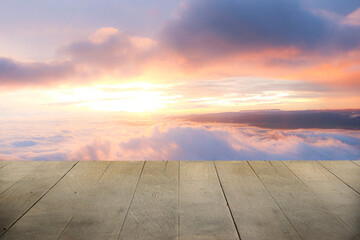 Wooden terrace with space for placing items or advertising media. There is a sunrise background in the morning.