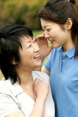 Naklejka premium A lady whispering a joke into her mother's ear