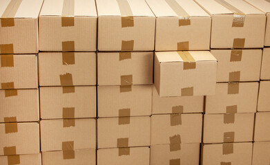 Cardboard boxes for delivery or moving. One box is special and taken out. Stack of boxes and blue background