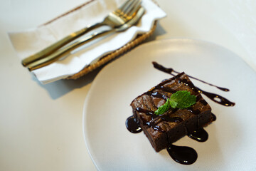 Close up chocolate fudge brownie on white ceramic plate