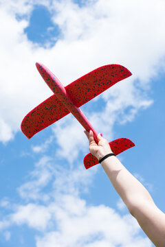 Hand of woman raising airplane toy