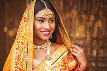 Beautiful young Indian woman dressed as a bride, wearing maang tikka and necklace with perl mala, her head covered with saree pallu - Powered by Adobe