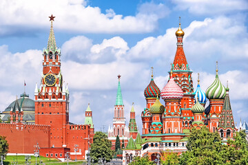 Fototapeta na wymiar famous moscow city russia kremlin landmark spasskaya clock tower and saint basil's cathedral on red square on summer against blue sky with clouds background. Street view of russian historic heritage