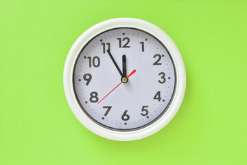 White clock on a green background   