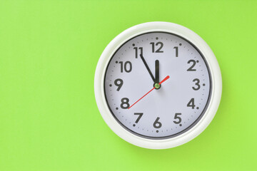 White clock on a green background   
