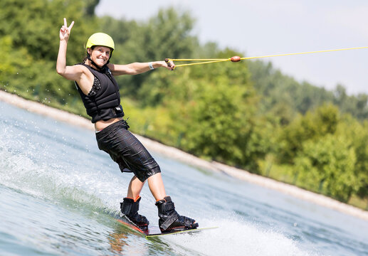 Junge Frau beim Wassersport zeigt Siegeszeichen