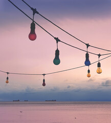 Light bulbs against sunset sky with  sea view on a background.