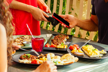 indian man paying in restaurant by credit card app on smartphone reader