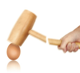 Tough egg to crack concept with hand holding hammer hitting egg, hammer breaks while egg stays intact, motion blur effect