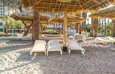 Tropical beach chairs and umbrellas, Middle East, near resort hotels and shore of the Red Sea