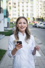 Fototapeta premium girl doctor in a white coat on the street