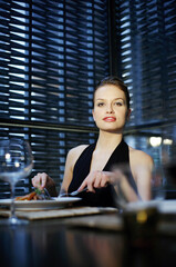 Naklejka na ściany i meble Woman enjoying her meal in a luxurious restaurant