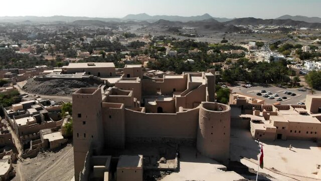 Overhead view of Hisn Tamah, also called Bahla fort, and the city of Bahla in Oman, famous touristic monument in the middle east and gulf area, surrounded by arid rocky mountains