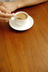 Hand stirring a cup of coffee