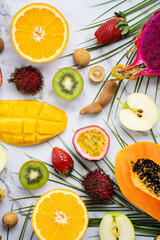 Exotic fruits and tropical leaves on table