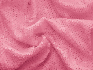 Background fabric sequin in pink color. Holiday abstract glitter background with blinking lights. Fashion fabric glitter. 