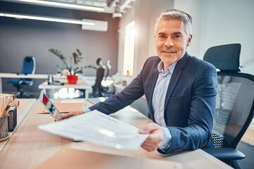 Entrepreneur of company sitting on the chair at his desk and giving a document